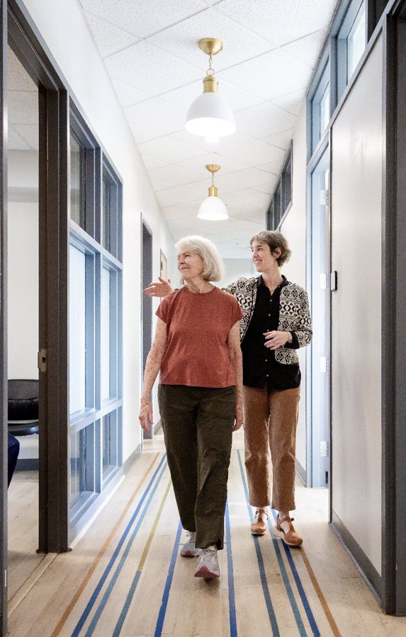 A patient walking the clinic hallway with her therapist